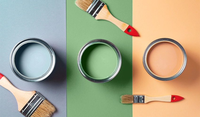 3 cans of paint blue, green, orange in overhead view